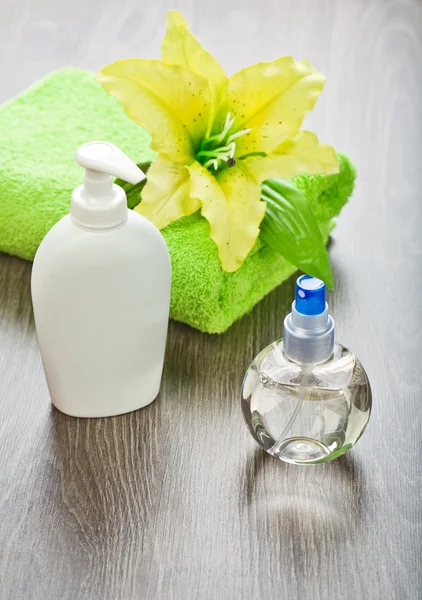 Handdoek met bloem en flessen — Stockfoto
