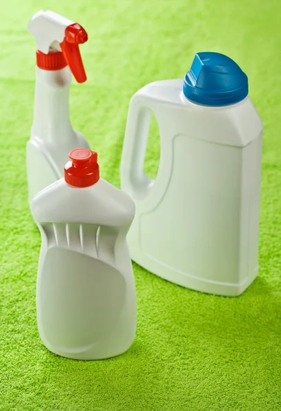 Três garrafas brancas no fundo verde — Fotografia de Stock