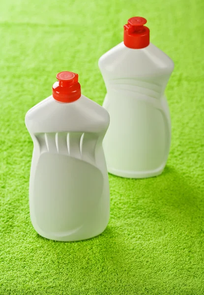 緑のタオルの上の 2 つのプラスチック製のボトル — ストック写真