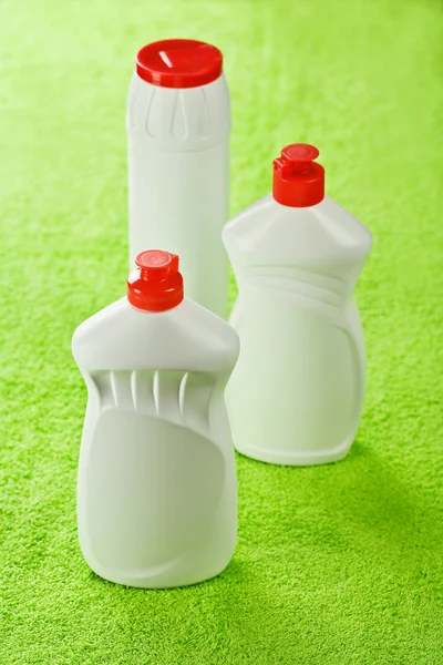 Trzy butelki na zielony ręcznik — Zdjęcie stockowe