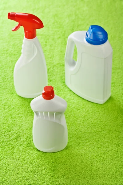 Três garrafas brancas de plástico no fundo verde — Fotografia de Stock