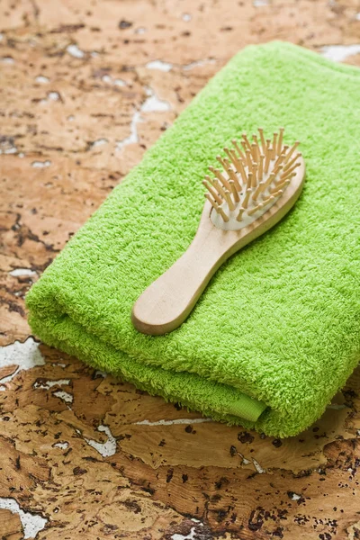 Asciugamano e spazzola per capelli su legno di sughero — Foto Stock