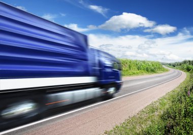 Blue truck speeding on country highway, motion blur clipart