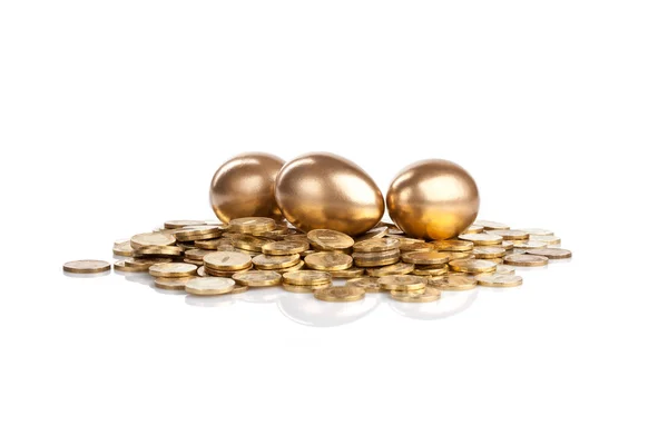 Τρία Χρυσά Αυγά Στα Νομίσματα Που Απομονώνονται Λευκό — Φωτογραφία Αρχείου