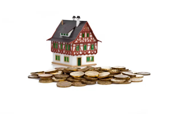 stock image Miniature house with the coins on white
