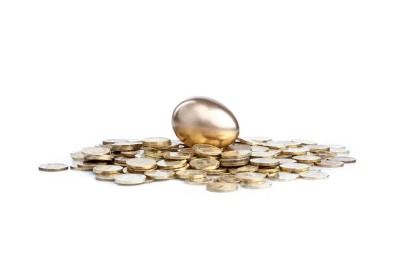 Золотое яйцо и монеты — стоковое фото
