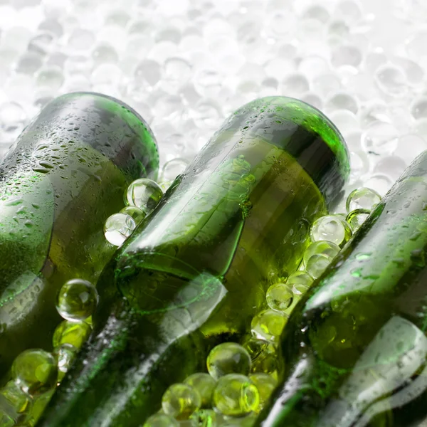 stock image Three green beer bottles in the ice