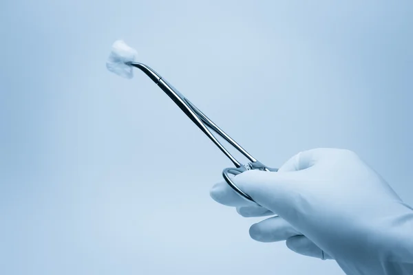 Hand van chirurg met een tang tijdens chirurgie — Stockfoto