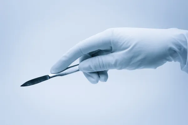 Main de chirurgien avec scalpel pendant la chirurgie — Photo