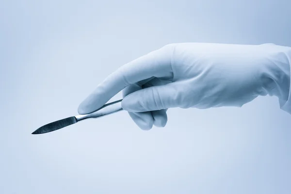 Mano del cirujano con bisturí durante la cirugía Imagen de stock