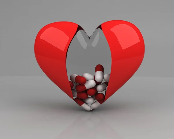 Прозрачное сердце с таблетками внутри на сером фоне — стоковое фото