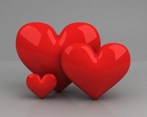 Τρεις κόκκινες καρδιές πέρα από το γκρι. σύμβολο του ένα ζευγάρι ερωτευμένων και τους — Stockfoto