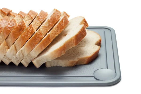 Pan rebanado sobre tabla de pan aislado sobre blanco — Foto de Stock