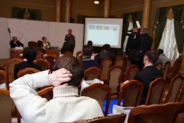 Publiken lyssnar agerar i en konferenssal. — Stockfoto