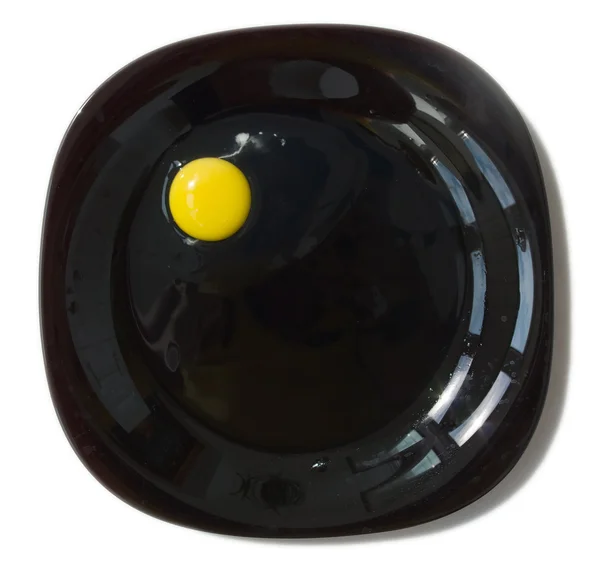 Сырое яйцо на черной тарелке — стоковое фото