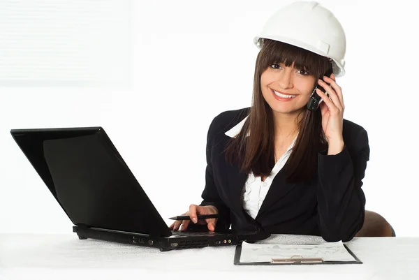 Girl sitting in the construction helmet — Stock Photo, Image