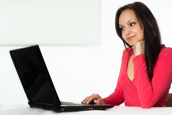 Flickan i röda med en bärbar dator — Stockfoto