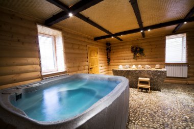 Bath with water in a beautiful wooden sauna clipart