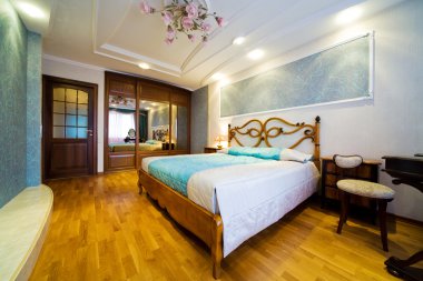 Bedroom with the chandelier in modern hotel clipart