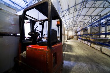 Red forklift in a large modern warehouse clipart