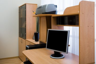 Modern computer on a desk near the window clipart