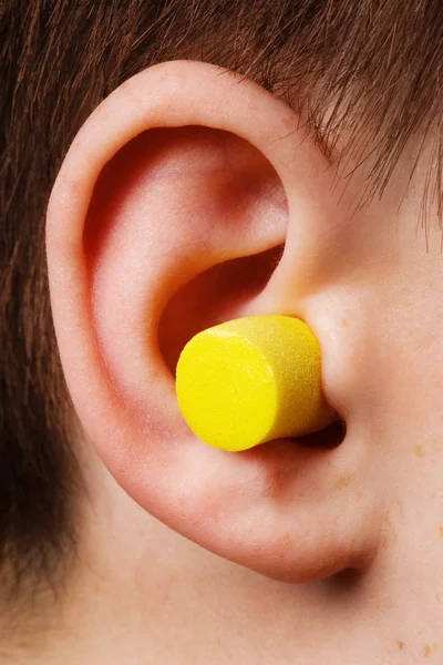 黄色の耳栓 耳にクローズ アップ — ストック写真
