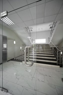 Glass doors with a kind on a marble staircase clipart