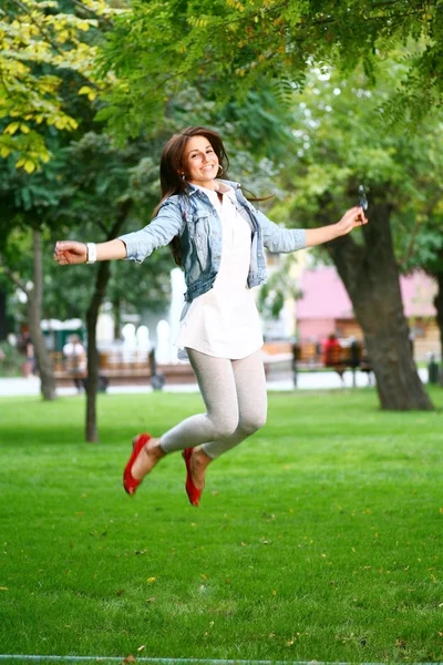 Junge Frau springt auf einem Gras — Stockfoto