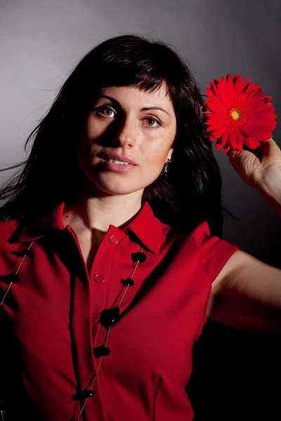 Приваблива жінка з червоною квіткою — стокове фото