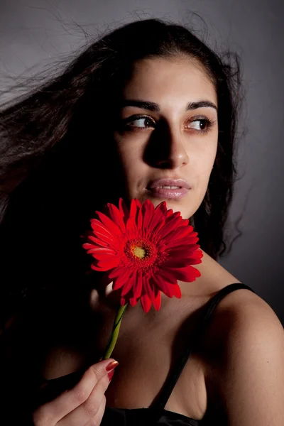 Ελκυστική γυναίκα με το κόκκινο λουλούδι — Φωτογραφία Αρχείου