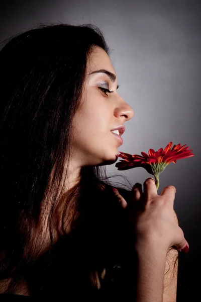 Ελκυστική γυναίκα με το κόκκινο λουλούδι — Φωτογραφία Αρχείου