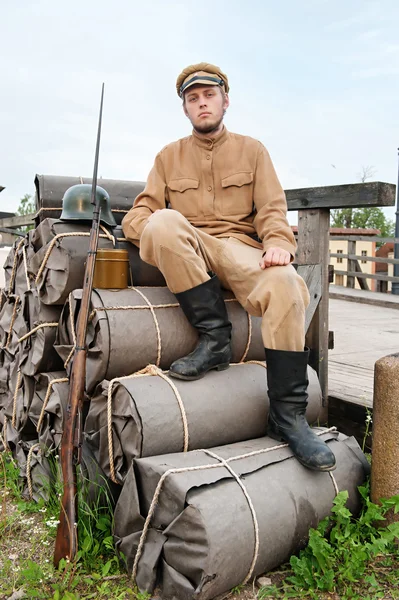 Retro style picture with soldier sitting on the bundles — Stock Photo, Image