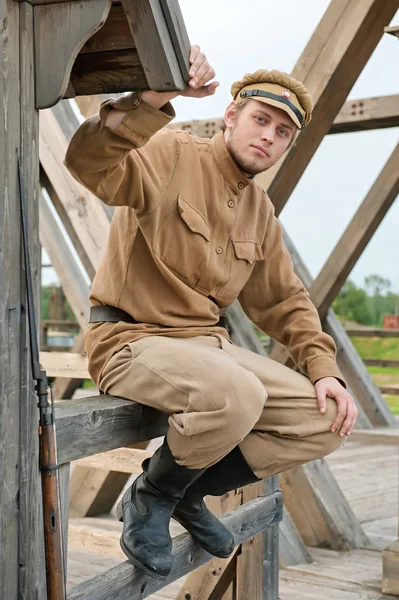銃を持った兵士が入り口の横に座っている 衣装は第一次世界大戦の時代に一致します ラトビアのシネマ シティ シニビージャで撮影 — ストック写真