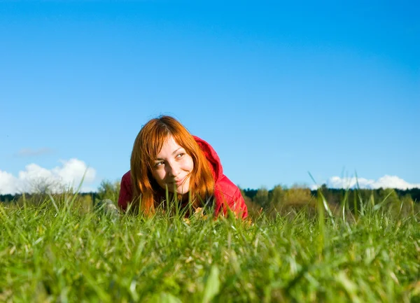Genç bir kadın çimenlerde yatıyor. — Stok fotoğraf