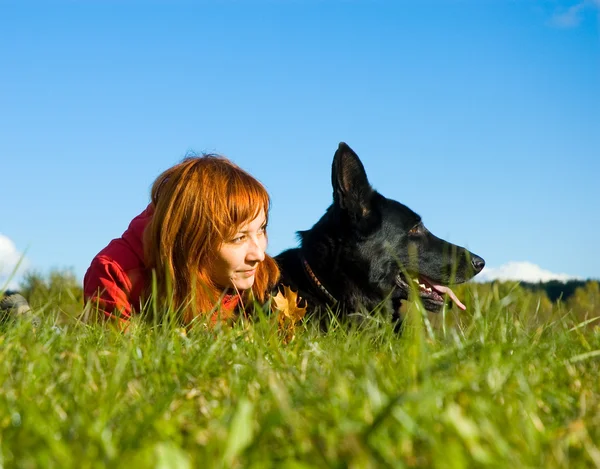 Femme et chien couchés sur l'herbe — Photo