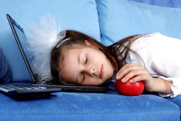 Trött tjej sova på laptop med rött äpple — Stockfoto
