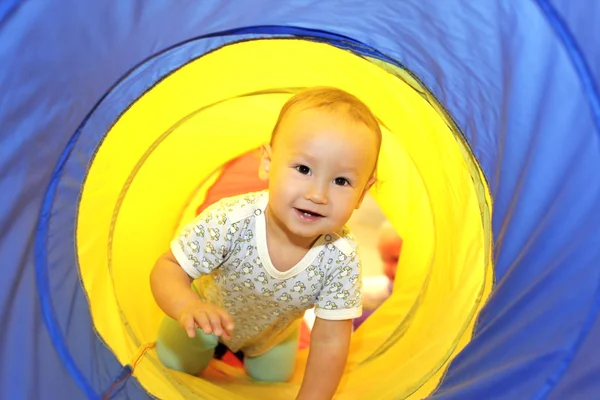Baby playing in tube — Stock Photo, Image