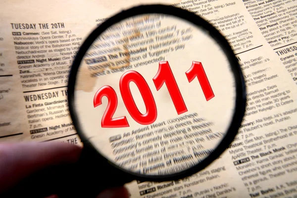 2011 text in old paper with magnifying glass — Stock Photo, Image