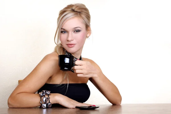 Woman with cup of hot drink against yellow wall at home — Stock Photo, Image