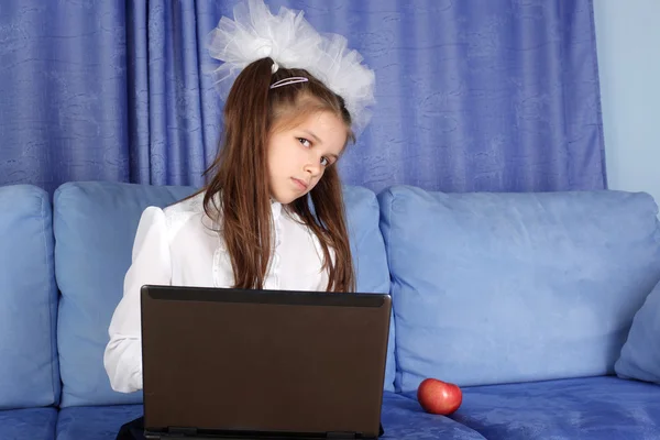 Δύσκολη μέρα στη μάθηση - κορίτσι με φορητό υπολογιστή και κόκκινο μήλο σε καναπέ — Φωτογραφία Αρχείου