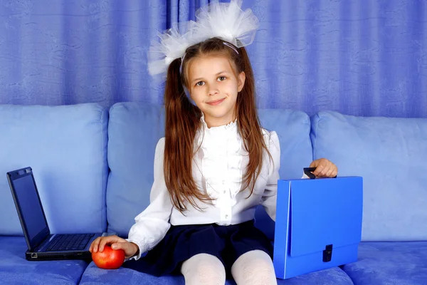 手提电脑、 案例和红苹果在沙发中的小女生 — 图库照片