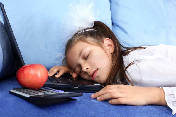 Chica cansada durmiendo en el ordenador portátil con manzana roja —  Fotos de Stock
