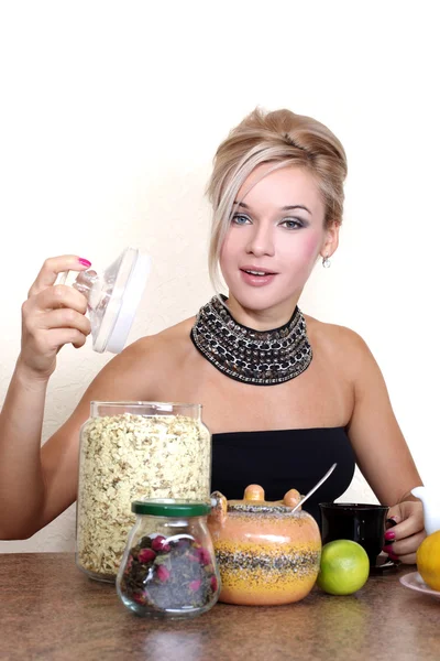 Mujer con taza de bebida caliente, limón, lima, té, pétalos de jazmín y — Foto de Stock