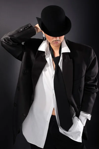 Молода модель моди в капелюсі, велика чоловіча сорочка і пальто проти чорного — стокове фото
