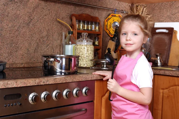 Malá holka vaří v kuchyni — Stock fotografie