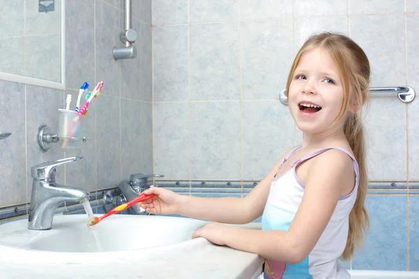 Petite fille avec brosse à dents dans la salle de bain — Photo