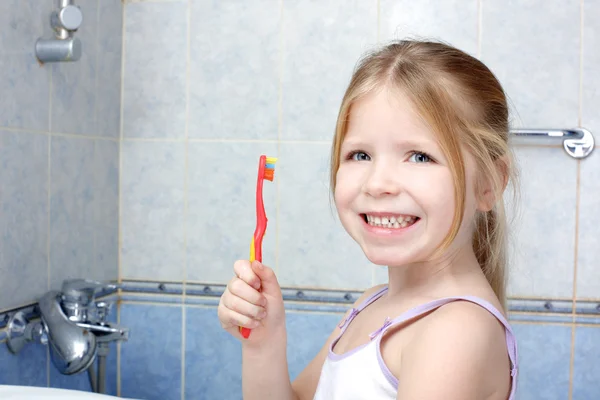 Niña con cepillo de dientes en el baño — Foto de Stock