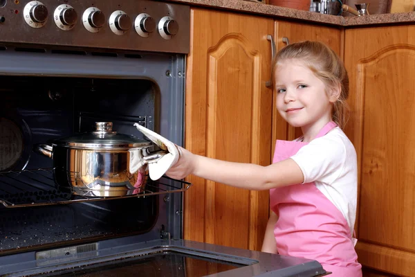 Κοριτσάκι, λαμβάνονται τα τρόφιμα από το φούρνο της κουζίνας — Φωτογραφία Αρχείου
