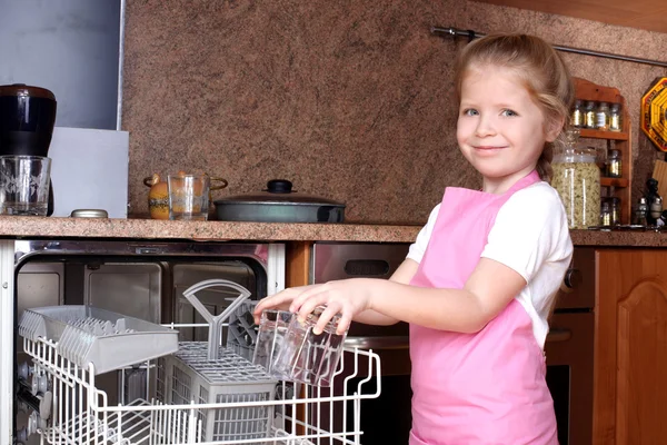 Bambina presa vetro trasparente dalla lavastoviglie in cucina — Foto Stock