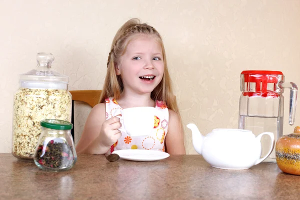 Fetiță cu ceașcă de băutură fierbinte, la masă cu ceai, jasmin peta — Fotografie, imagine de stoc